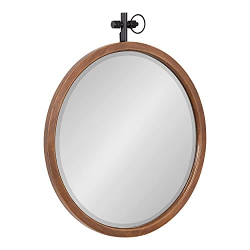 A round wall mirror in a styled entryway