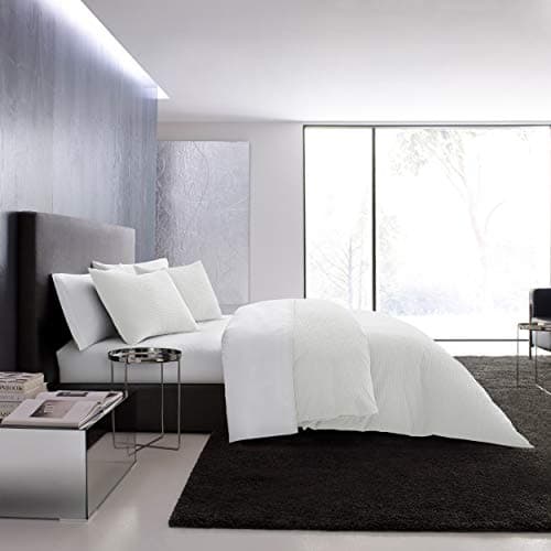 A made bed with layered linens in a cozy bedroom