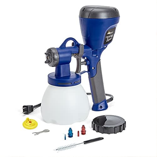 Using a paint sprayer on furniture in a workshop