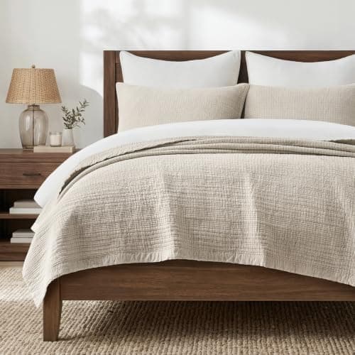 A made bed with layered linens in a cozy bedroom
