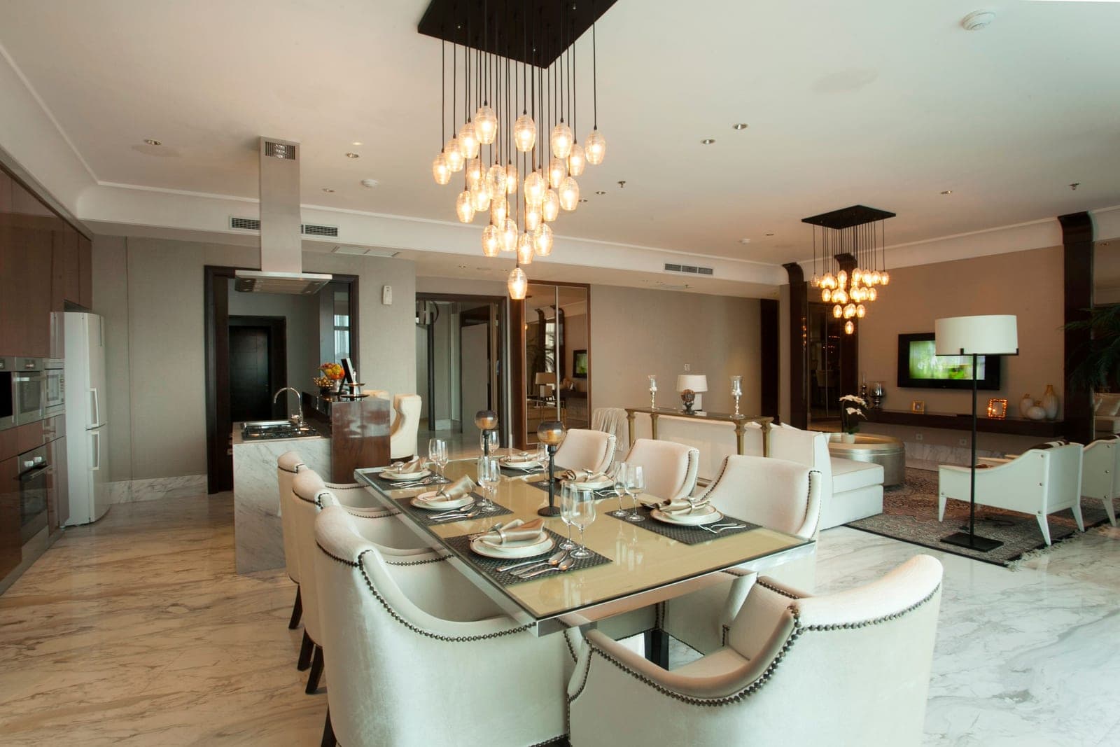 An open-plan living room and dining space in warm neutral tones