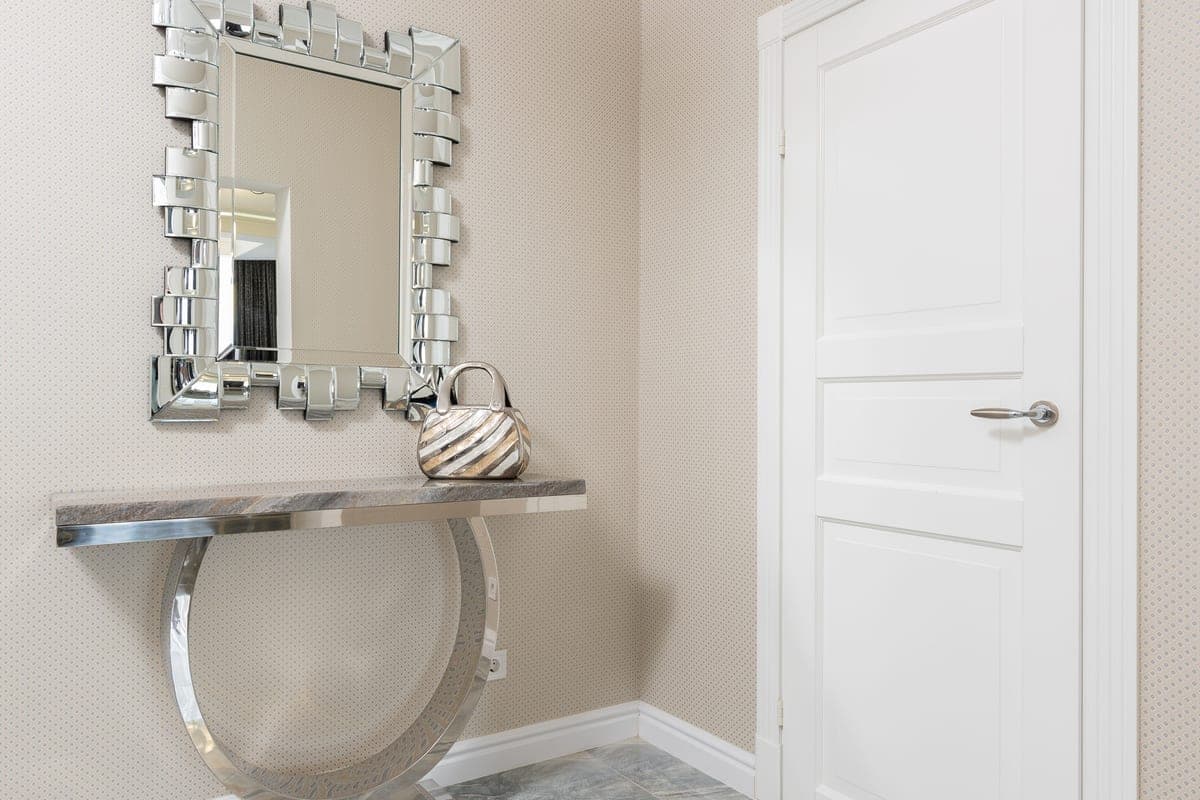 An entryway console table with decor and a mirror