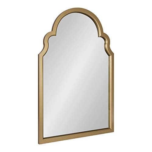 A round wall mirror in a styled entryway