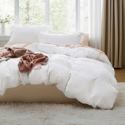 A made bed with layered linens in a cozy bedroom