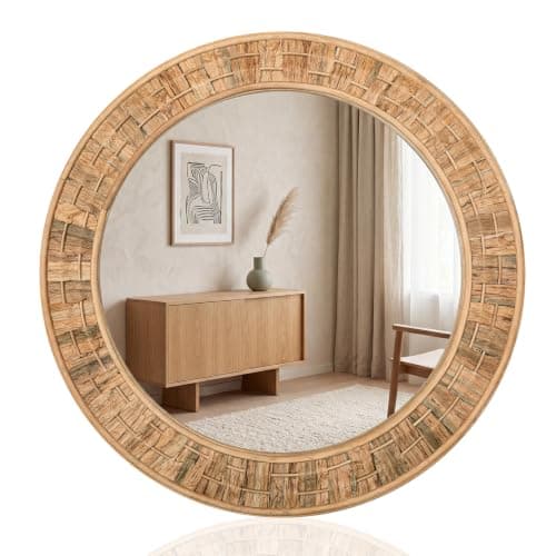 A round wall mirror in a styled entryway